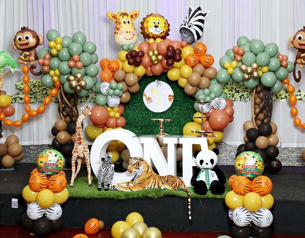 Jungle safari theme kids birthday decoration in Melbourne with sage green, white and gold balloon garland, safari animal props and custom name backdrop by JK Deco.