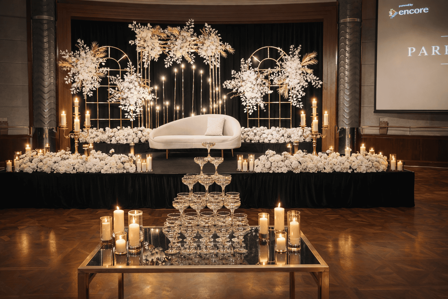 Elegant wedding stage setup with white flowers, candles, and sophisticated lighting for luxury recep.